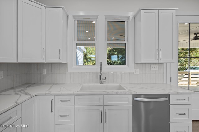 kitchen with white cabinetry, dishwasher, sink, tasteful backsplash, and light stone counters