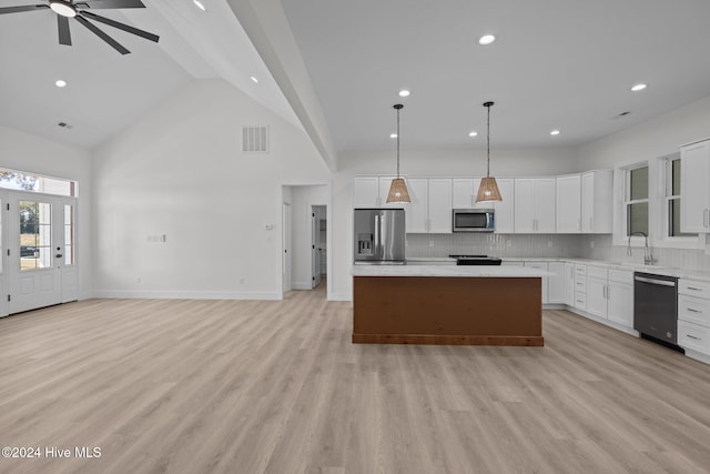 kitchen featuring stainless steel appliances, a kitchen island, and white cabinetry