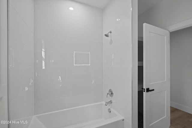 bathroom featuring wood-type flooring and tiled shower / bath combo