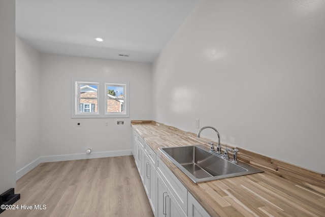 kitchen with sink, white cabinets, and light hardwood / wood-style floors