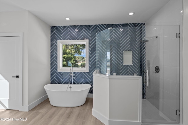 bathroom featuring hardwood / wood-style floors and plus walk in shower