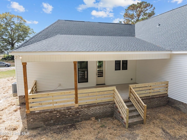 back of property with a deck and cooling unit