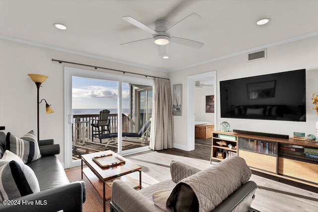 living room with ornamental molding, light hardwood / wood-style floors, and ceiling fan