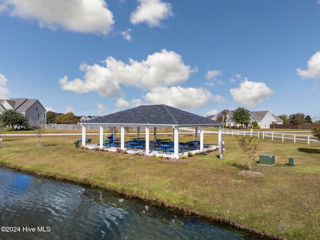 exterior space featuring a water view, a gazebo, and a lawn