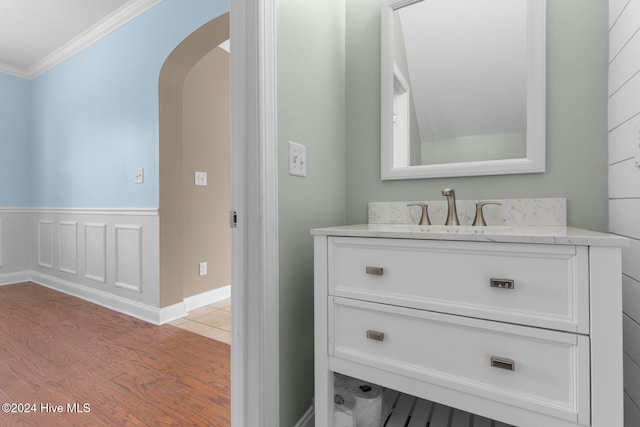 bathroom featuring vanity, crown molding, and hardwood / wood-style flooring