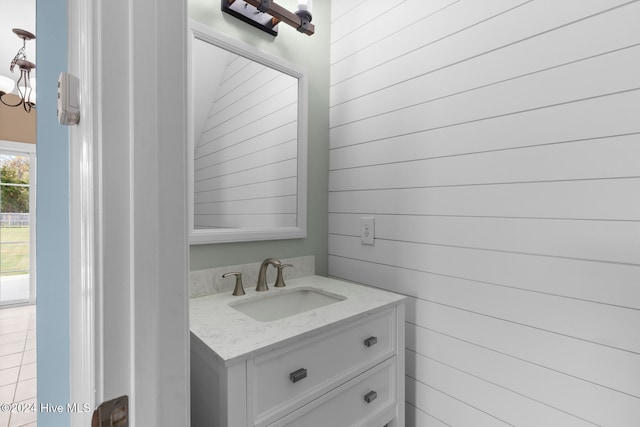 bathroom with vanity and wooden walls