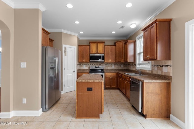 kitchen with sink, a kitchen island, light tile patterned flooring, and stainless steel appliances