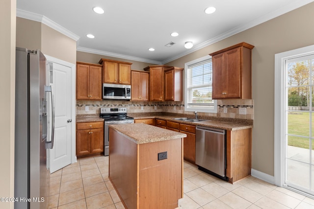 kitchen featuring ornamental molding, a kitchen island, stainless steel appliances, and backsplash