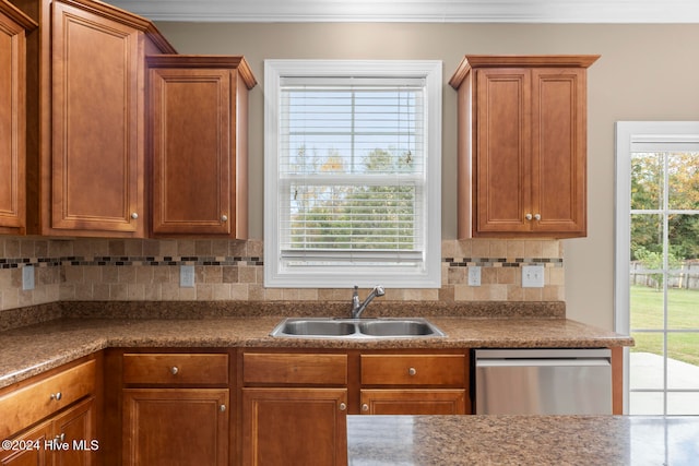 kitchen featuring stainless steel dishwasher, sink, and backsplash