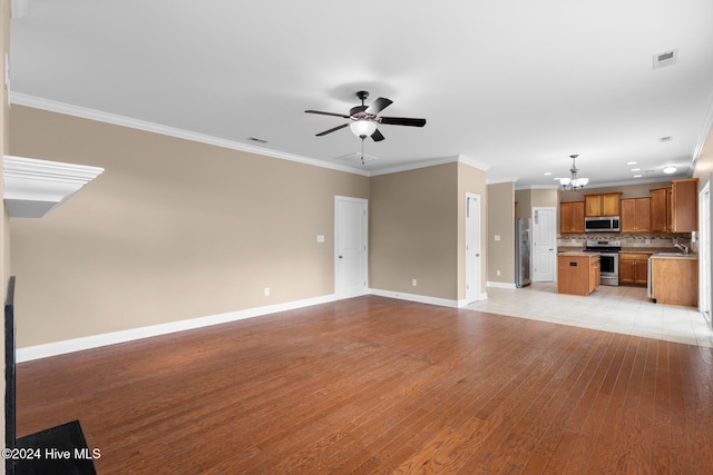 unfurnished living room with sink, ornamental molding, light hardwood / wood-style flooring, and ceiling fan with notable chandelier