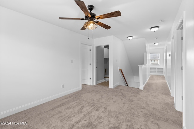 carpeted spare room featuring ceiling fan