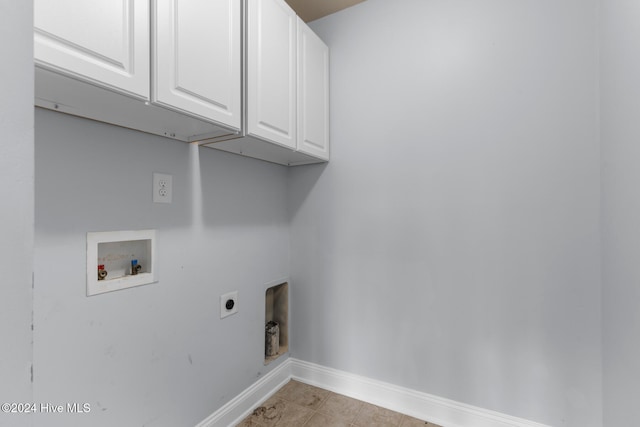 clothes washing area featuring cabinets, light tile patterned flooring, washer hookup, and electric dryer hookup