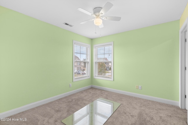 carpeted spare room with ceiling fan