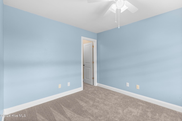 spare room featuring light carpet and ceiling fan