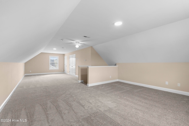 additional living space featuring lofted ceiling, light colored carpet, and ceiling fan