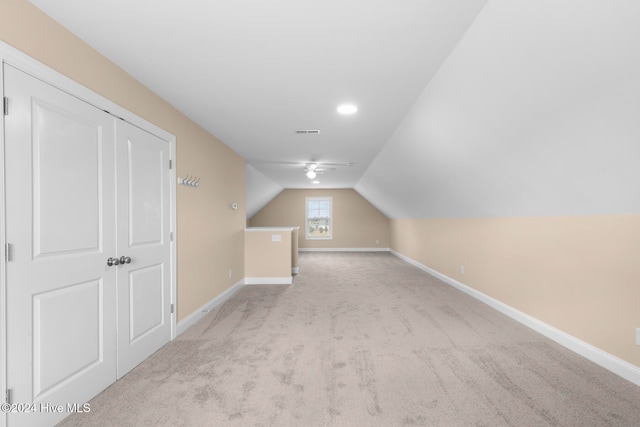 additional living space with vaulted ceiling and light colored carpet