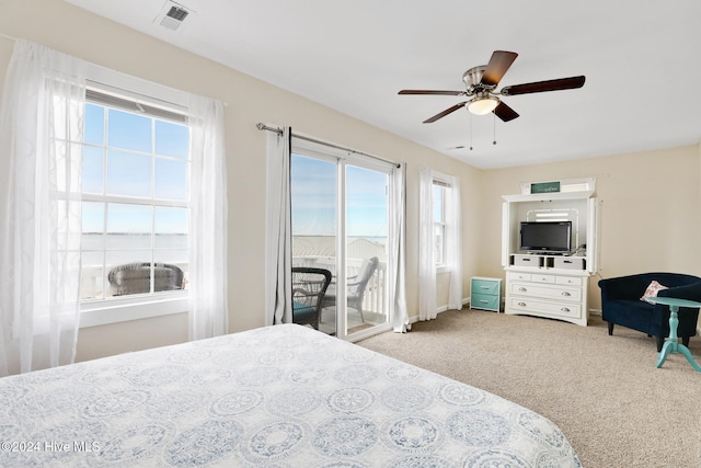 bedroom with ceiling fan, access to outside, multiple windows, and light colored carpet