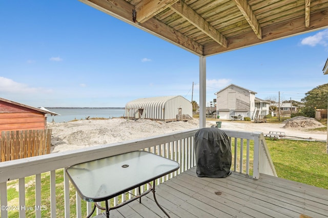 wooden terrace featuring area for grilling and a water view