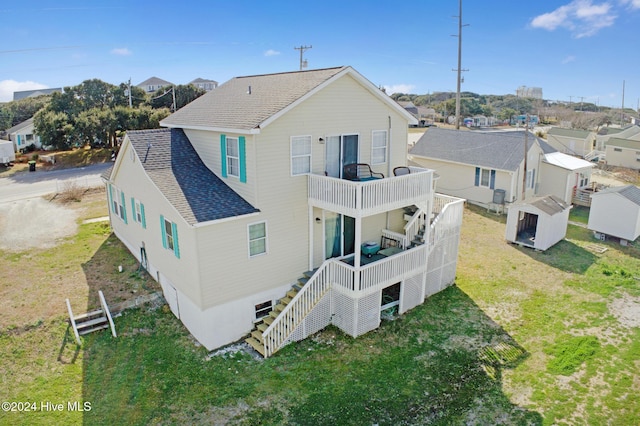 back of house featuring a shed, a yard, and a balcony