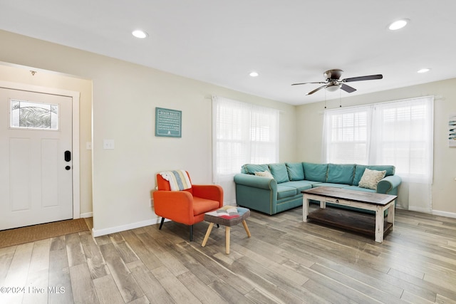 living room featuring light hardwood / wood-style floors and ceiling fan