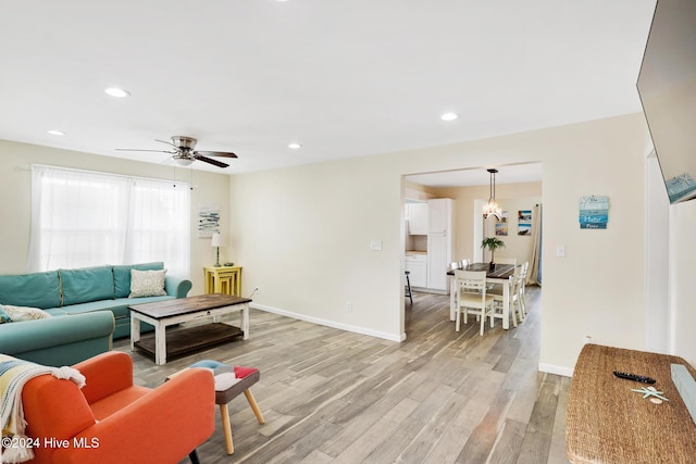 living room featuring light wood-type flooring and ceiling fan