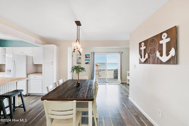 dining area with an inviting chandelier and dark wood-type flooring