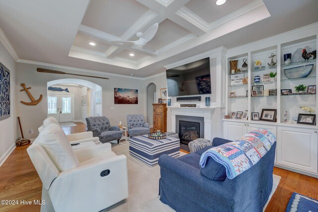 living room with light hardwood / wood-style floors, beamed ceiling, ornamental molding, and coffered ceiling