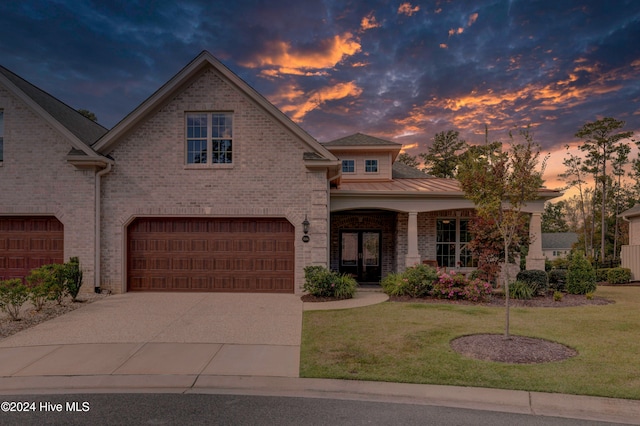 view of front of home featuring a garage and a lawn