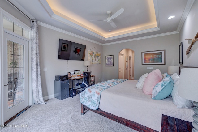 bedroom with crown molding, light carpet, ceiling fan, and a raised ceiling