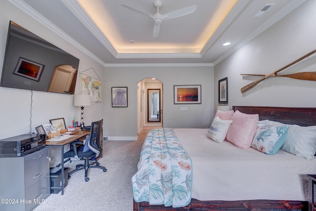 bedroom with ceiling fan, light colored carpet, a raised ceiling, and crown molding