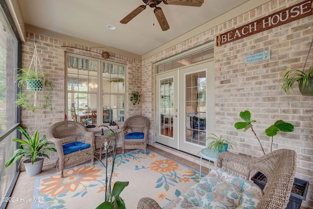 sunroom / solarium featuring a wealth of natural light, french doors, and ceiling fan