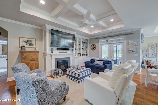 living room with french doors, crown molding, light wood-type flooring, coffered ceiling, and beamed ceiling