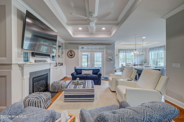 living room featuring light hardwood / wood-style floors, a wealth of natural light, and ornamental molding