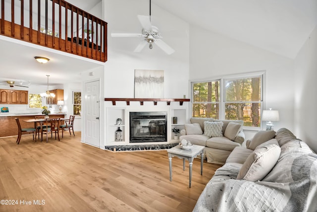 living room with light hardwood / wood-style flooring, high vaulted ceiling, and ceiling fan