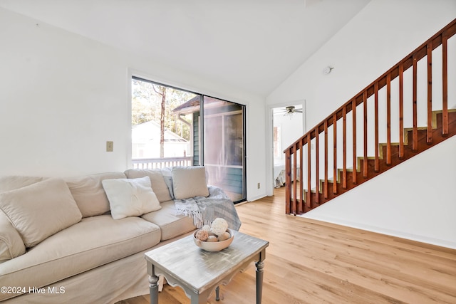 living room featuring light hardwood / wood-style floors, high vaulted ceiling, and ceiling fan