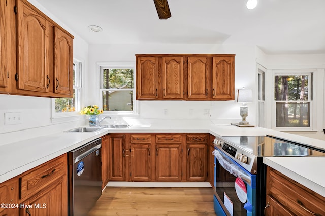 kitchen with light hardwood / wood-style floors, appliances with stainless steel finishes, and sink