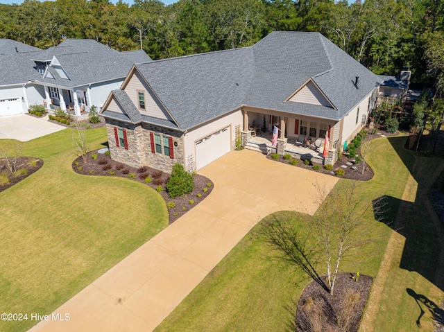 craftsman house featuring a porch, a front lawn, and a garage