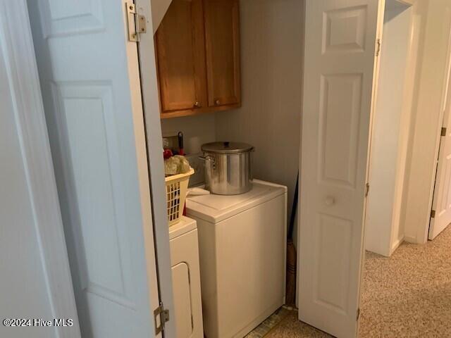 clothes washing area with cabinets and independent washer and dryer