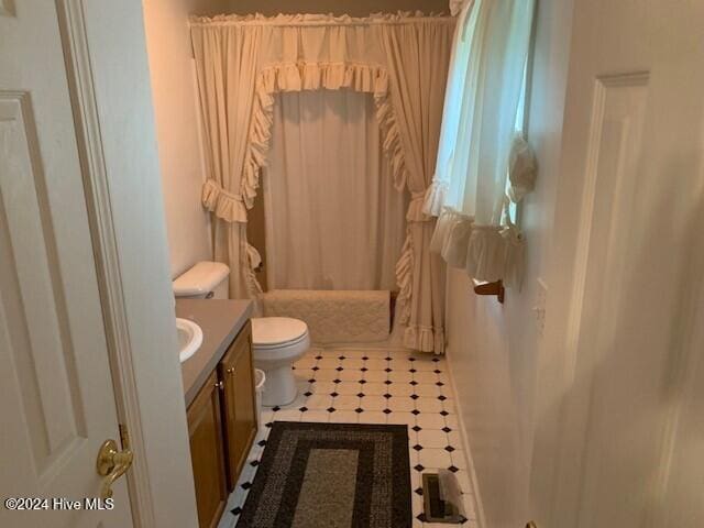 full bathroom featuring vanity, shower / bath combination with curtain, toilet, and tile patterned flooring