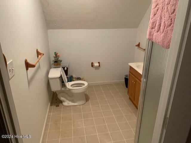 bathroom featuring vanity, tile patterned flooring, toilet, and walk in shower