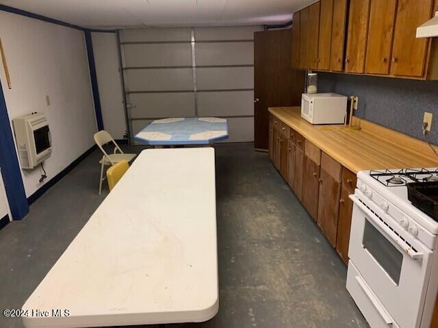 kitchen featuring decorative backsplash, ventilation hood, heating unit, and white appliances