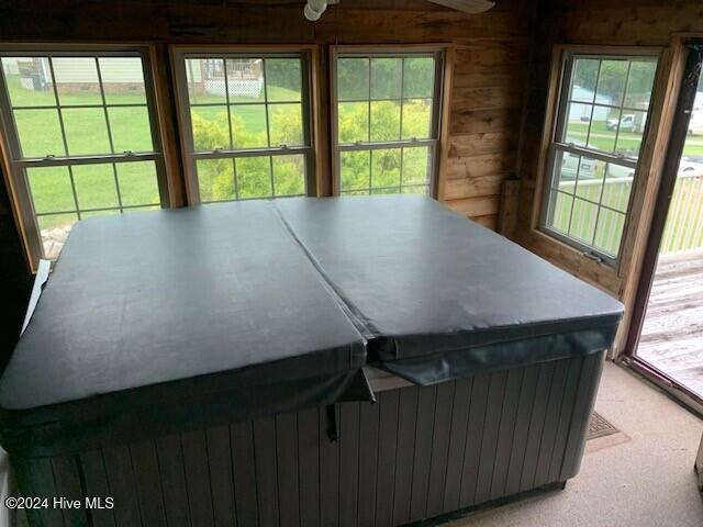 sunroom / solarium with a hot tub, ceiling fan, and a wealth of natural light