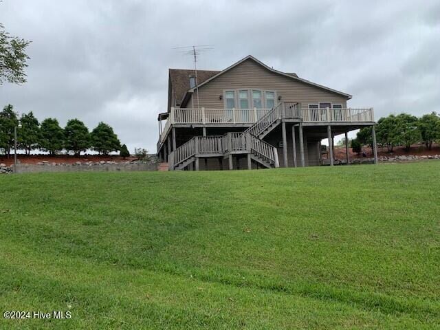 back of property featuring a yard and a wooden deck