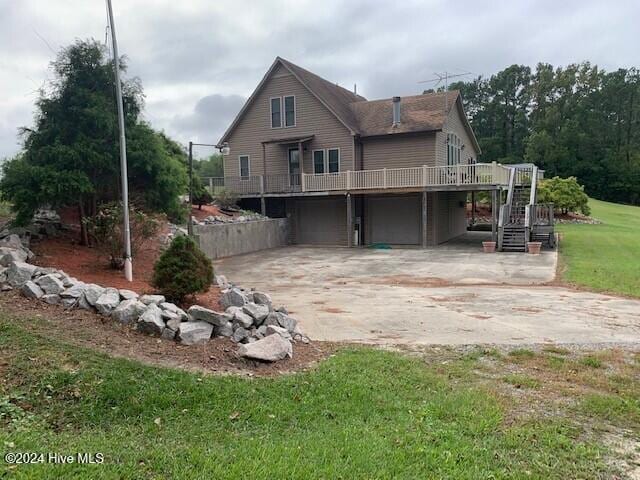 rear view of property featuring a garage and a lawn