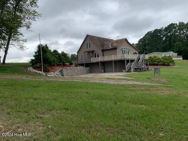 rear view of house with a wooden deck and a yard