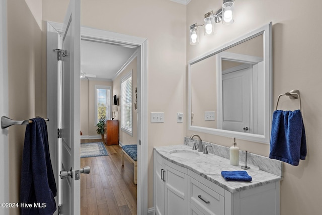 bathroom with crown molding, hardwood / wood-style floors, vanity, and ceiling fan