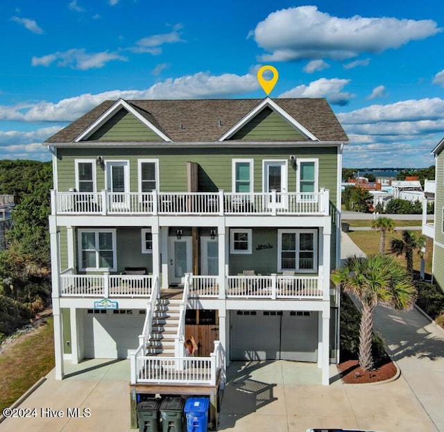 raised beach house featuring a porch, a garage, and a balcony