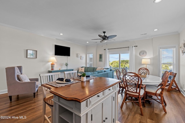 dining space featuring ceiling fan, wood-type flooring, and ornamental molding