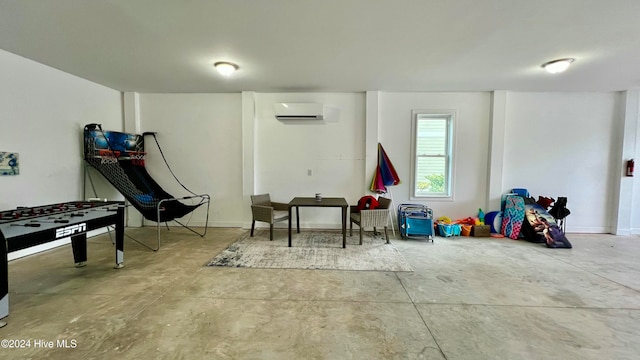 playroom with concrete flooring and a wall mounted air conditioner