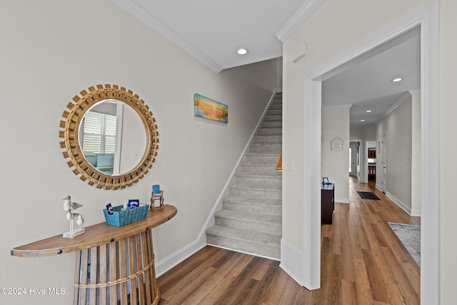 stairs featuring hardwood / wood-style flooring and crown molding